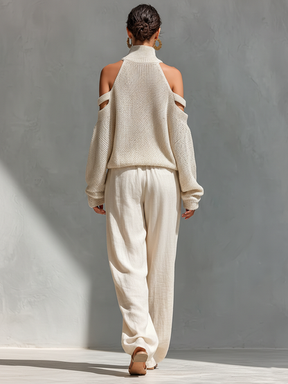 Conjunto de mujer con top de punto beige de cuello alto y hombros al descubierto, y pantalones de pierna ancha